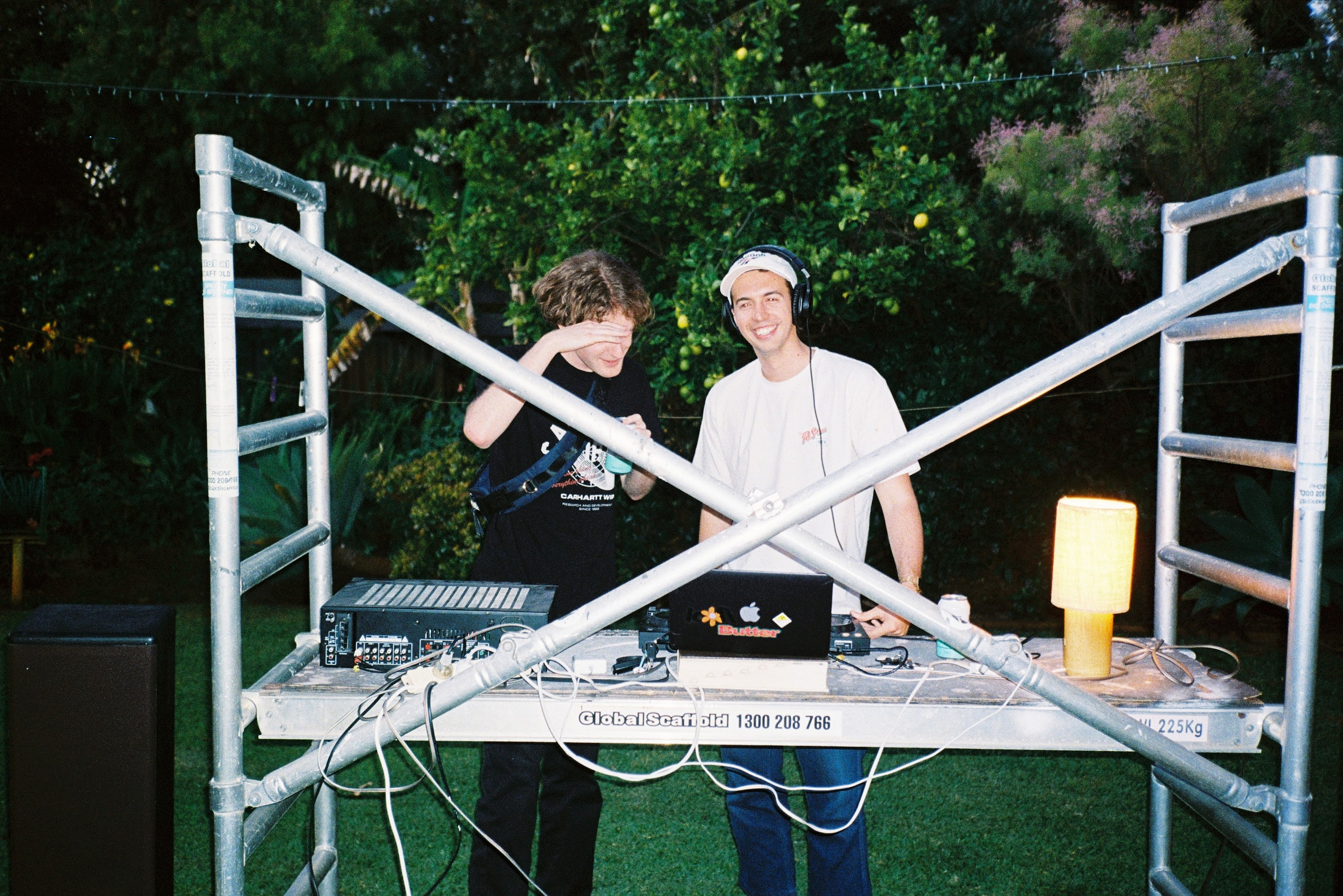 Cover photo of two housemates DJing at a house party.