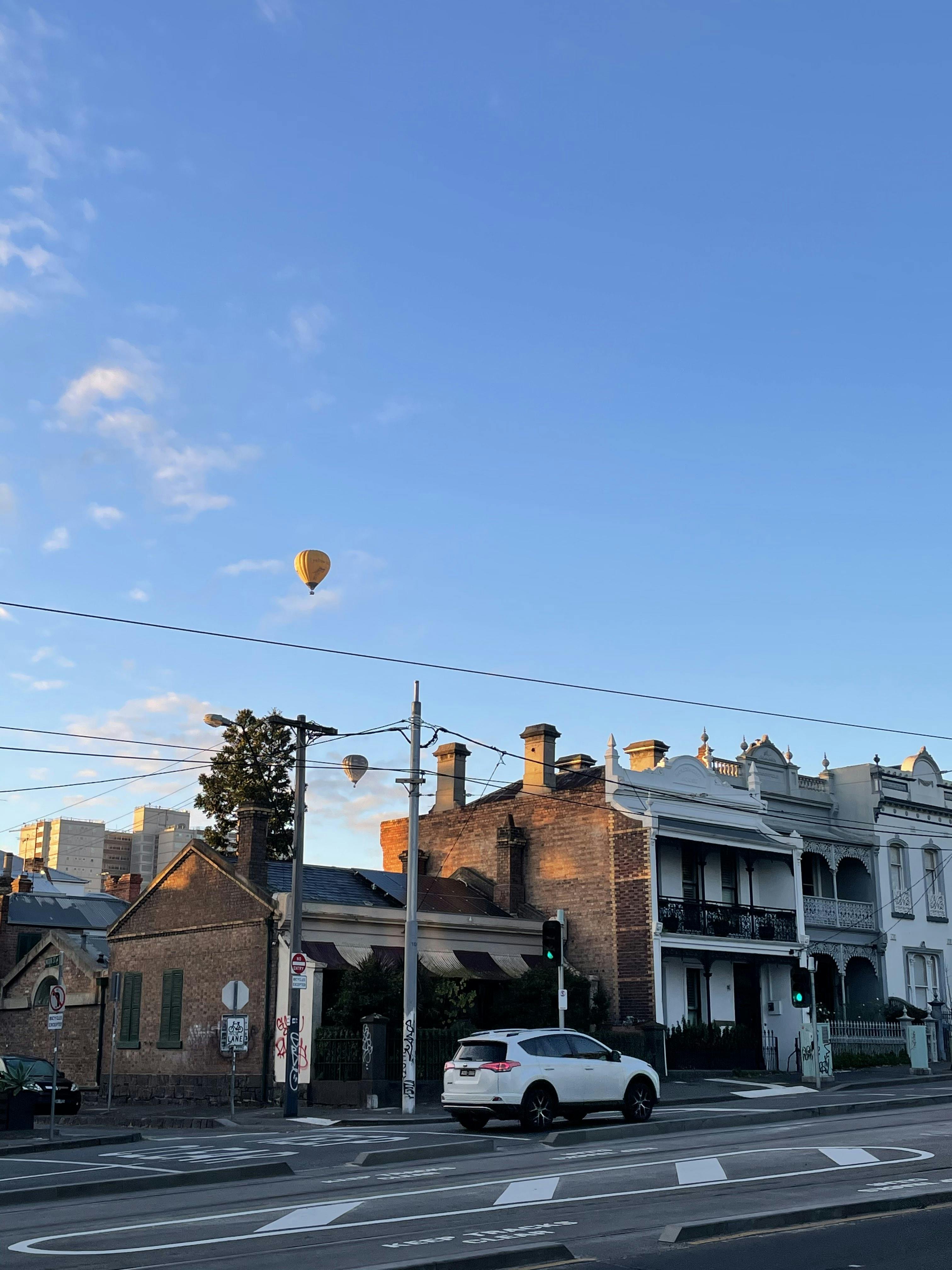 Cover image for blog post showing hot air ballon floating above Fitzroy terrace houses in Melbourne